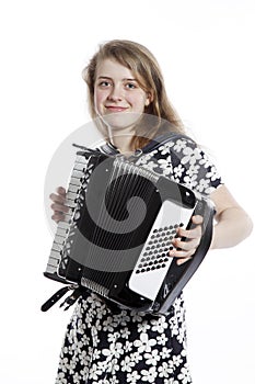 Smiling teenage girl stands in studio with accordion