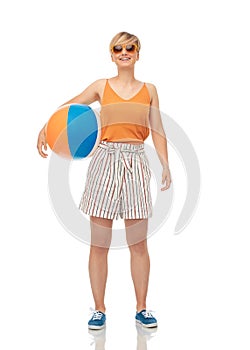 Smiling teenage girl in sunglasses with beach ball