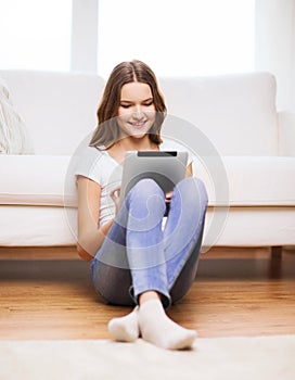 Smiling teenage girl with tablet pc at home