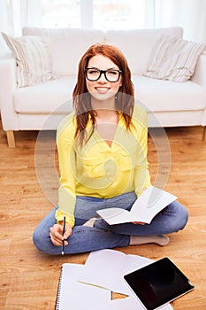 Smiling teenage girl with tablet pc at home