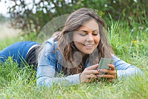 Smiling teenage girl using smart phone outdoors