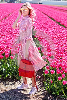 Smiling teenage girl walks through tulip field