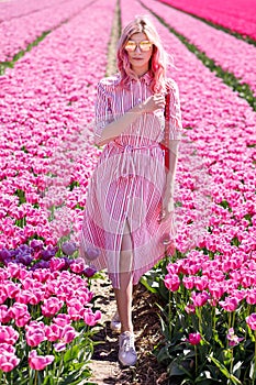 Smiling teenage girl walks through tulip field