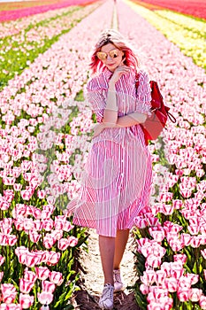 Smiling teenage girl walks through tulip field