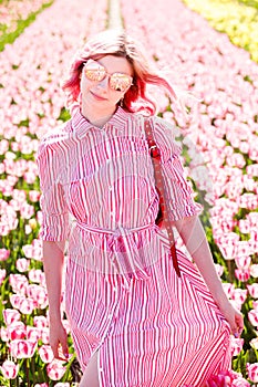 Smiling teenage girl walks through tulip field