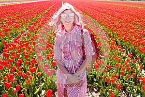 Smiling teenage girl walks through tulip field