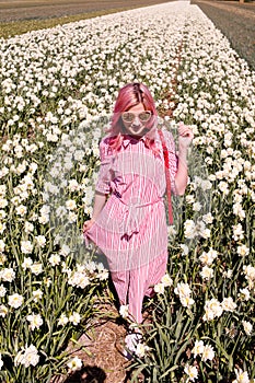 Smiling teenage girl walks through tulip field