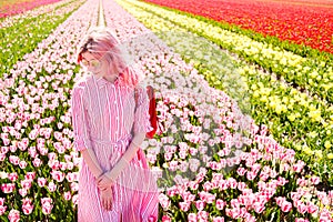 Smiling teenage girl walks through tulip field