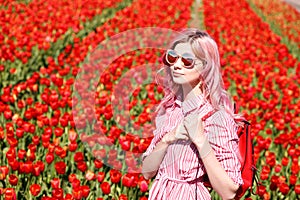 Smiling teenage girl walks through tulip field