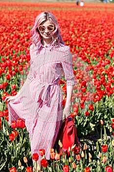 Smiling teenage girl walks through tulip field