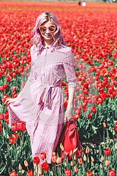 Smiling teenage girl walks through tulip field