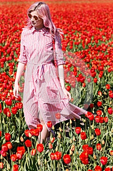 Smiling teenage girl walks through tulip field