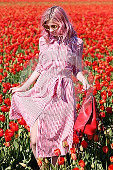 Smiling teenage girl walks through tulip field