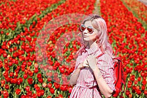 Smiling teenage girl walks through tulip field