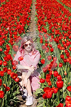 Smiling teenage girl walks through tulip field