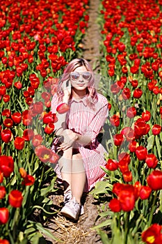 Smiling teenage girl walks through tulip field