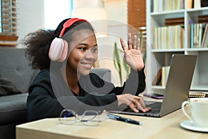 Smiling teenage girl watching learning online in virtual classroom on laptop laptop. E-learning education concept