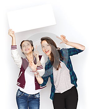 Smiling teenage girls holding white blank board
