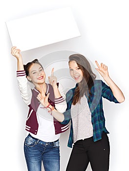 Smiling teenage girls holding white blank board