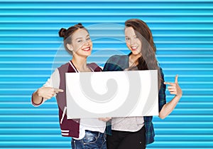 Smiling teenage girls holding white blank board