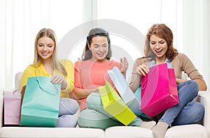 Smiling teenage girls with many shopping bags