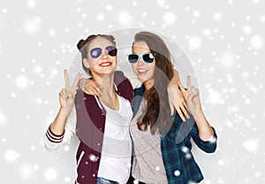 Smiling teenage girls in sunglasses showing peace