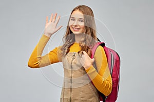 Smiling teenage student girl with backpack