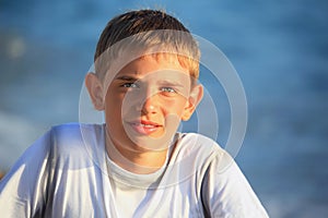 Smiling teenager boy against sea photo