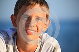 Smiling teenager boy against sea photo