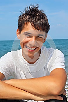 Smiling teenager boy against sea