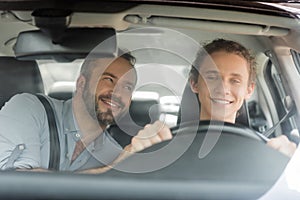 smiling teenager boy holding steering wheel