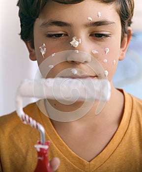 Smiling teenager boy with white paint roller and dirty face make repaint