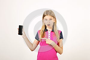 Smiling teenager girl in casual outfit posing with mobile phone, showing emotions, making funny faces. Isolated white background.