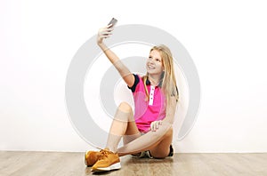 Smiling teenager girl in casual outfit posing with mobile phone, showing emotions, making funny faces. Isolated white background.