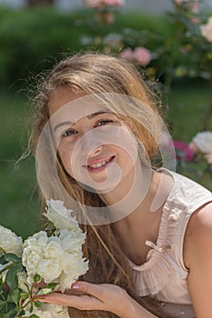 Smiling teenager girl with long blonde hair holding a bunch of w