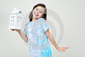 Smiling teenager girl with a mock up at home on a white background with copy space. immovable property