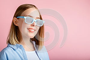 Smiling teenager girl portrait movie viewer in glasses isolated over pink color background with copy space. Young woman in cinema