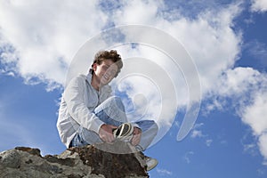 Smiling teenager sitting on a wall