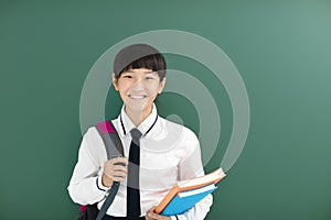 Smiling teenager Student girl stand before chalkboard