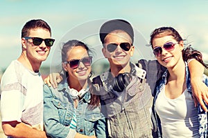 Smiling teenagers in sunglasses hanging outside