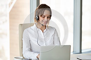 Smiling telemarketer wearing headset consulting customer making