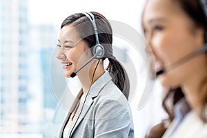 Smiling telemarketing Asian woman in call center