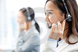 Smiling telemarketing Asian woman working in call center photo