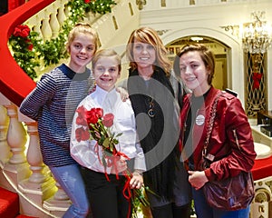 Smiling ten-year-old girl standing on a red stairway with Mother and sisters