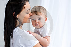 smiling tender mother holding cute baby boy