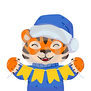 Smiling tiger with santa hat, warm sweater and festive garland flags. Chinese zodiac animal. Symbol of the new year 2022, 2034.