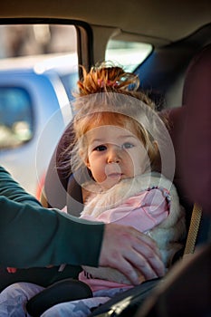 Smiling toddler girl sitting in the car seat