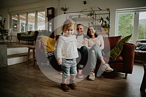 Smiling toddler girl standing ready to dance at home