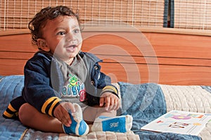 Smiling toddler having fun with a book