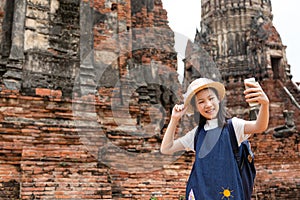 Smiling tourist girl taking self-portrait picture with smartphone photo